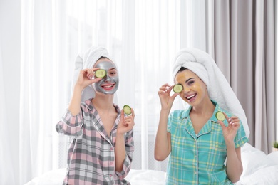 Photo of Young friends with facial masks having fun in room at pamper party