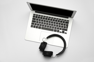 Photo of Modern headphones and laptop on white background, top view