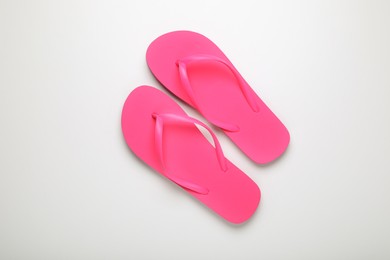 Stylish pink flip flops on white background, top view