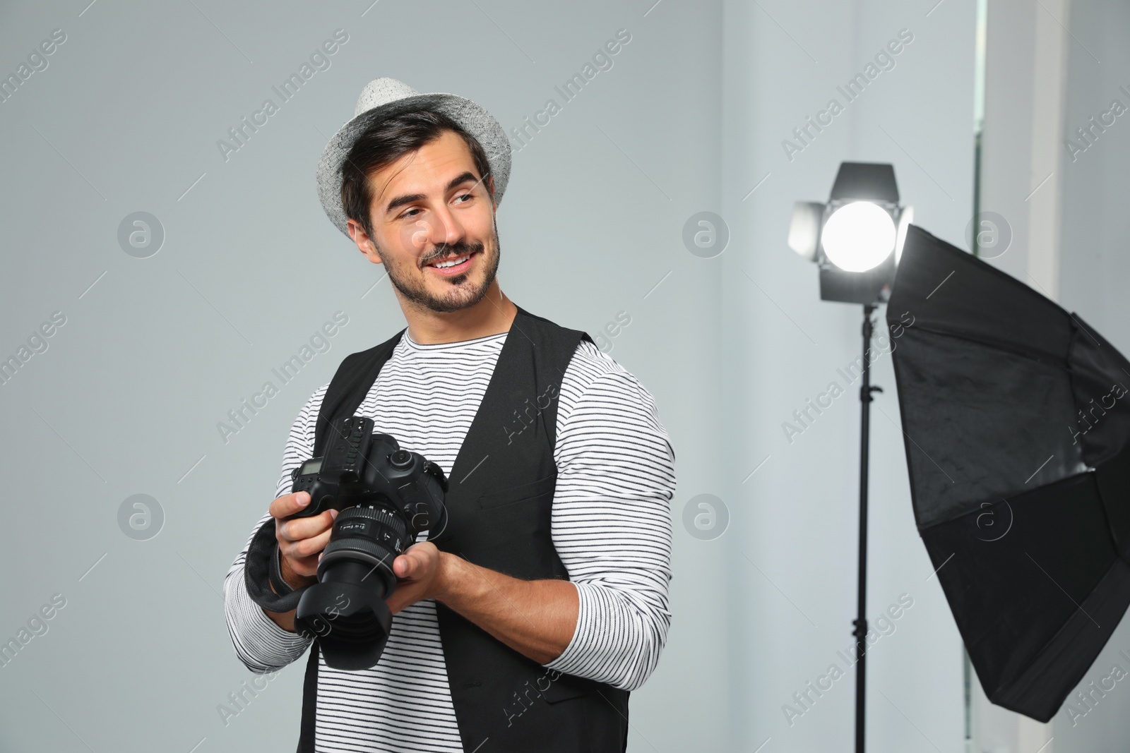 Photo of Professional photographer with modern camera in studio