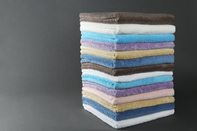 Different fresh soft terry towels on grey background