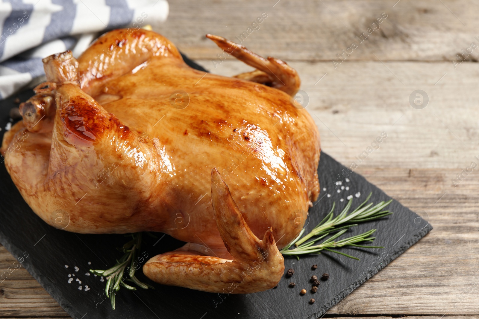 Photo of Tasty roasted chicken with spices on wooden table