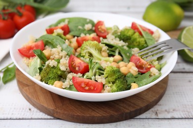 Photo of Healthy meal. Tasty salad with quinoa, chickpeas and vegetables on white wooden table, closeup