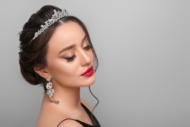Photo of Beautiful young woman wearing luxurious tiara on light grey background, space for text