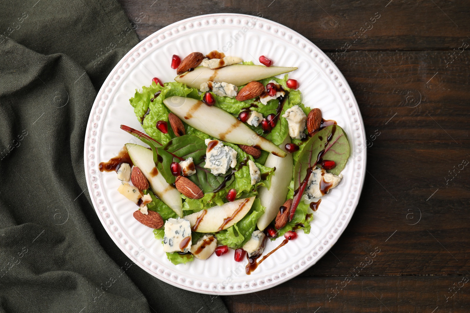 Photo of Delicious pear salad with sauce on wooden table, top view