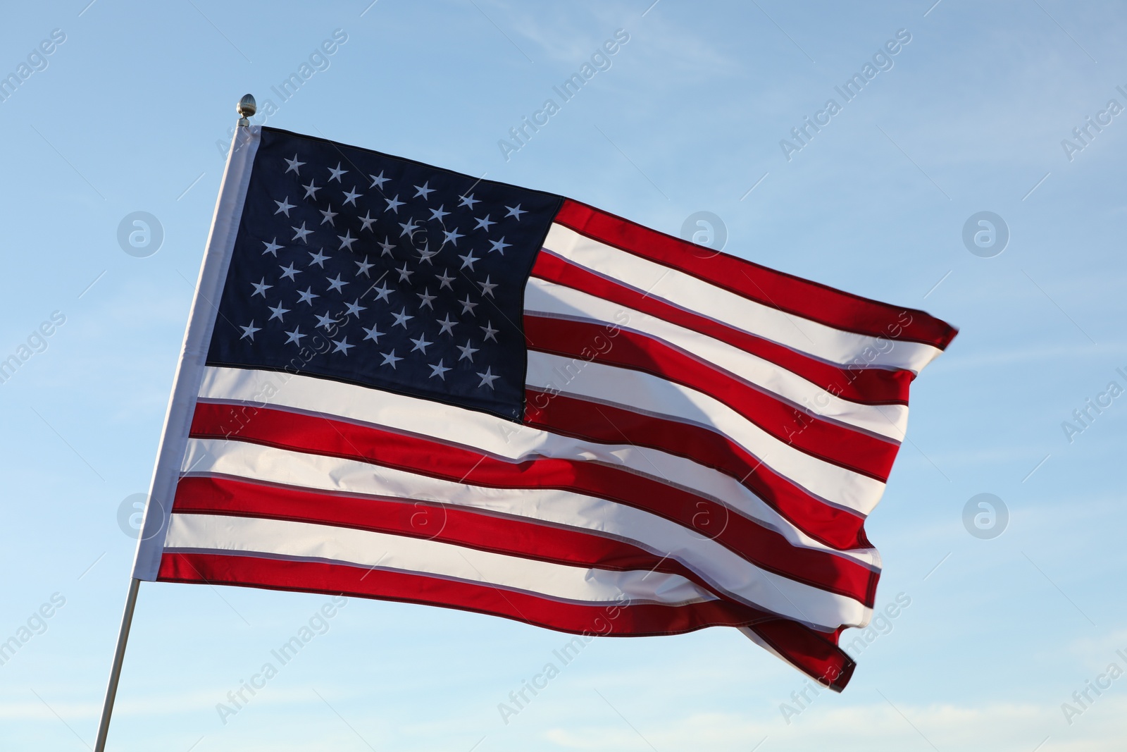 Photo of American flag fluttering outdoors on sunny day