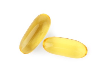 Photo of Two yellow vitamin capsules isolated on white, top view