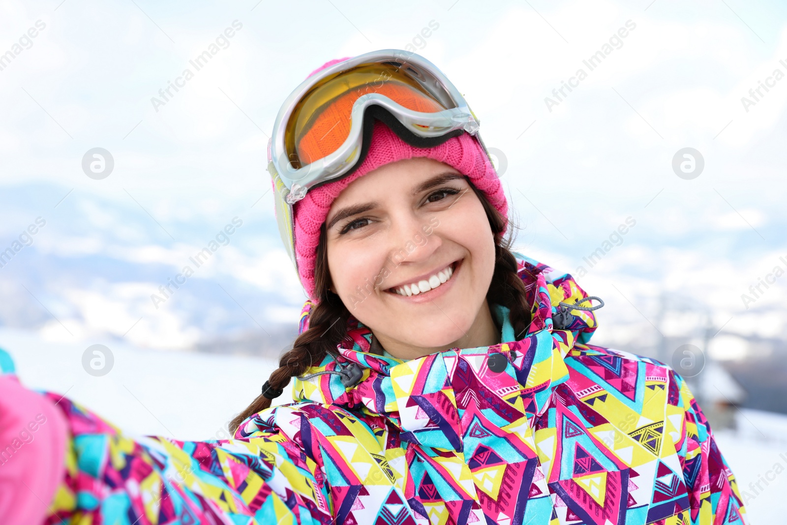Photo of Young woman taking selfie at mountain resort. Winter vacation