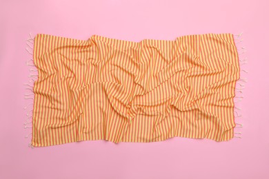 Photo of Crumpled striped beach towel on pink background, top view