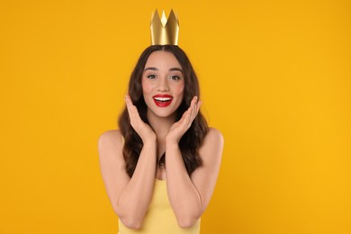 Photo of Beautiful young woman with princess crown on yellow background