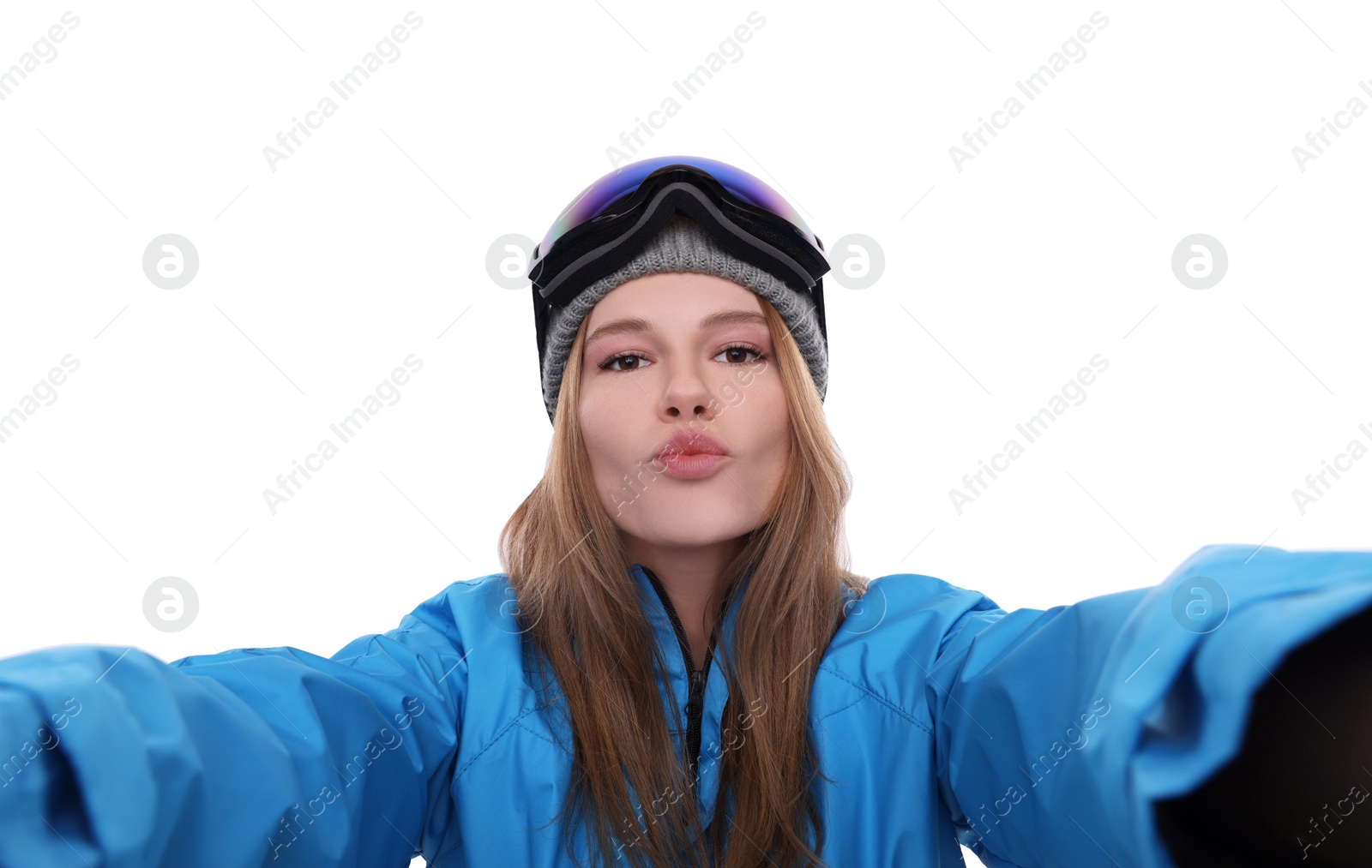 Photo of Beautiful woman in ski goggles taking selfie on white background