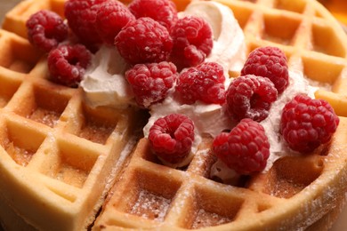 Photo of Tasty Belgian waffle with fresh raspberries and whipped cream, closeup