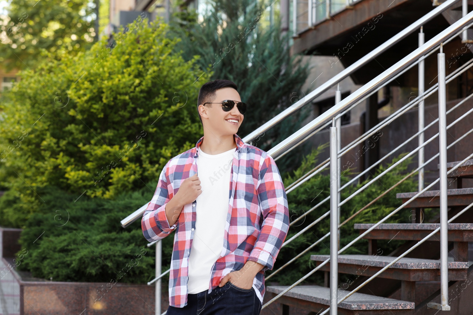 Photo of Young man in stylish outfit outdoors. T-shirt as mockup for design