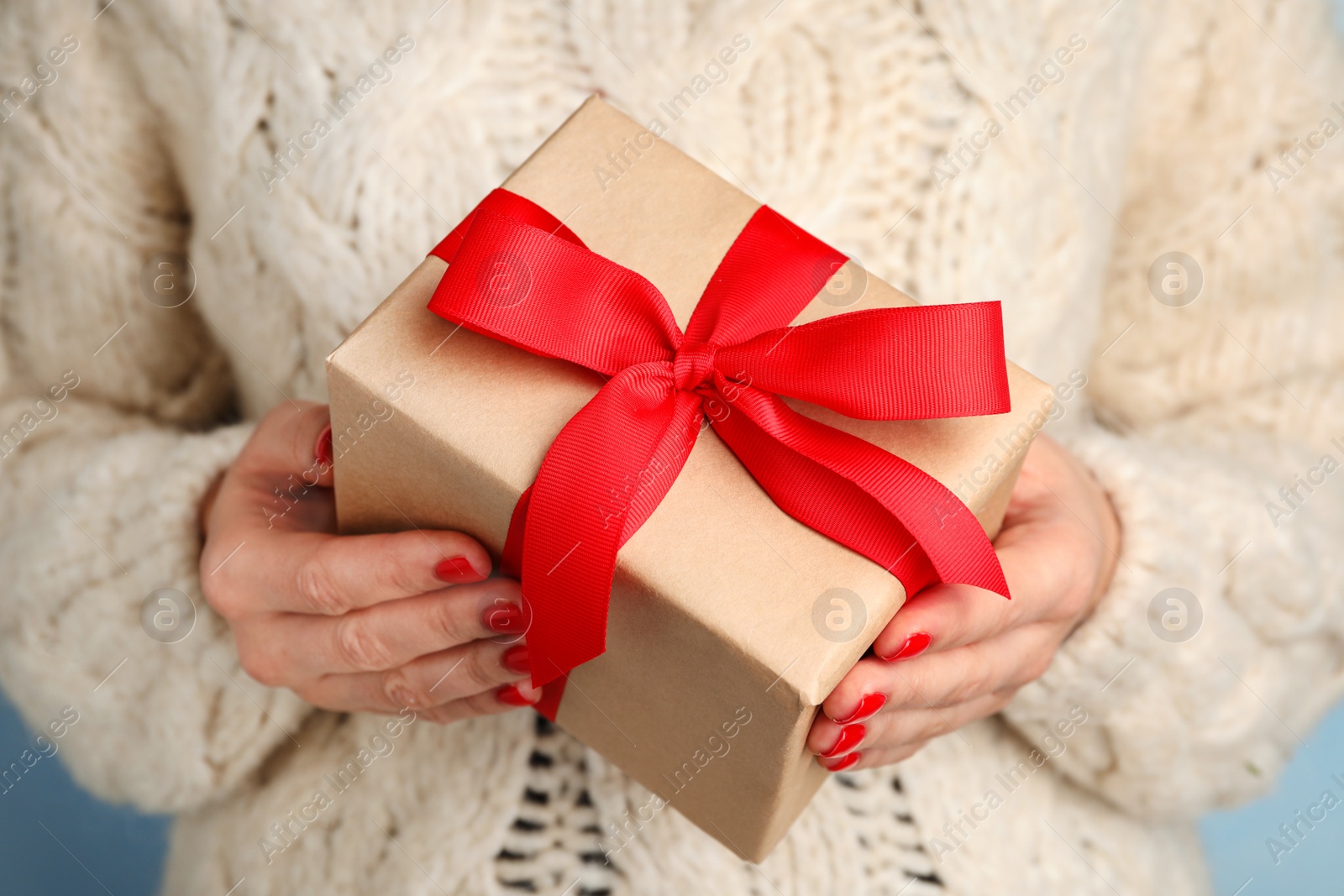 Photo of Young woman holding Christmas gift, closeup view