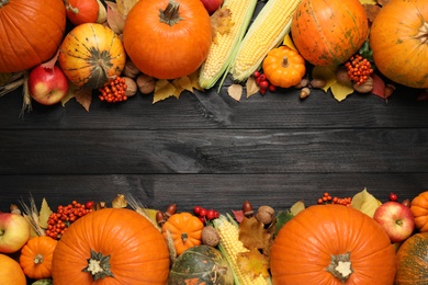 Photo of Frame of ripe pumpkins and autumn leaves on black wooden table, flat lay with space for text. Happy Thanksgiving day