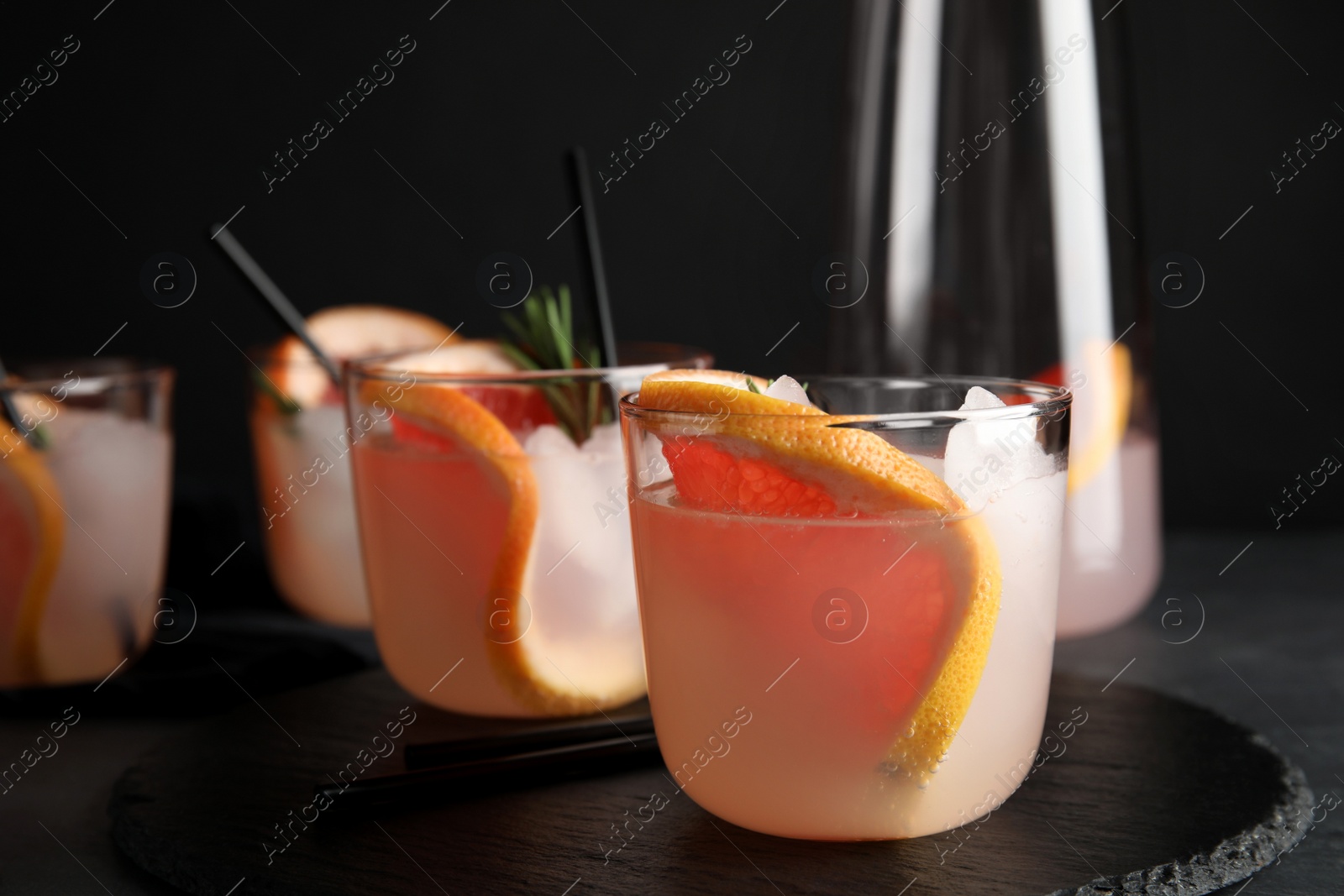 Photo of Slate plate with glasses of grapefruit cocktails on table. Space for text