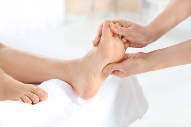 Photo of Woman receiving foot massage in wellness center, closeup