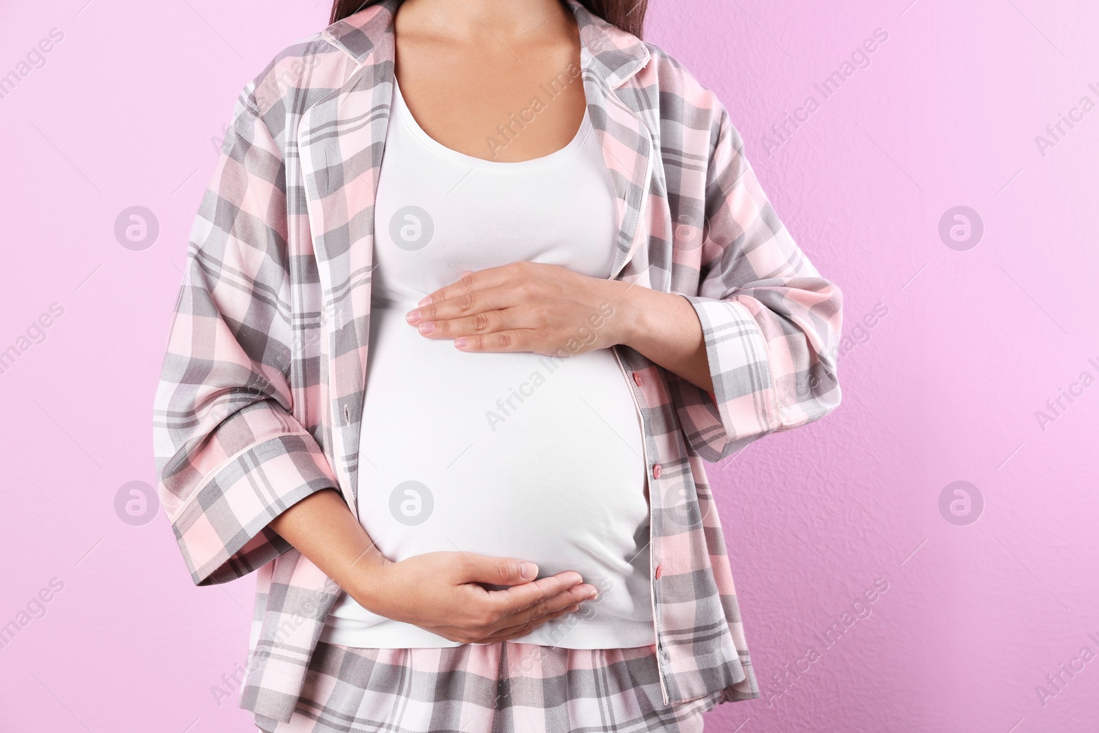 Photo of Pregnant woman posing on color background, closeup