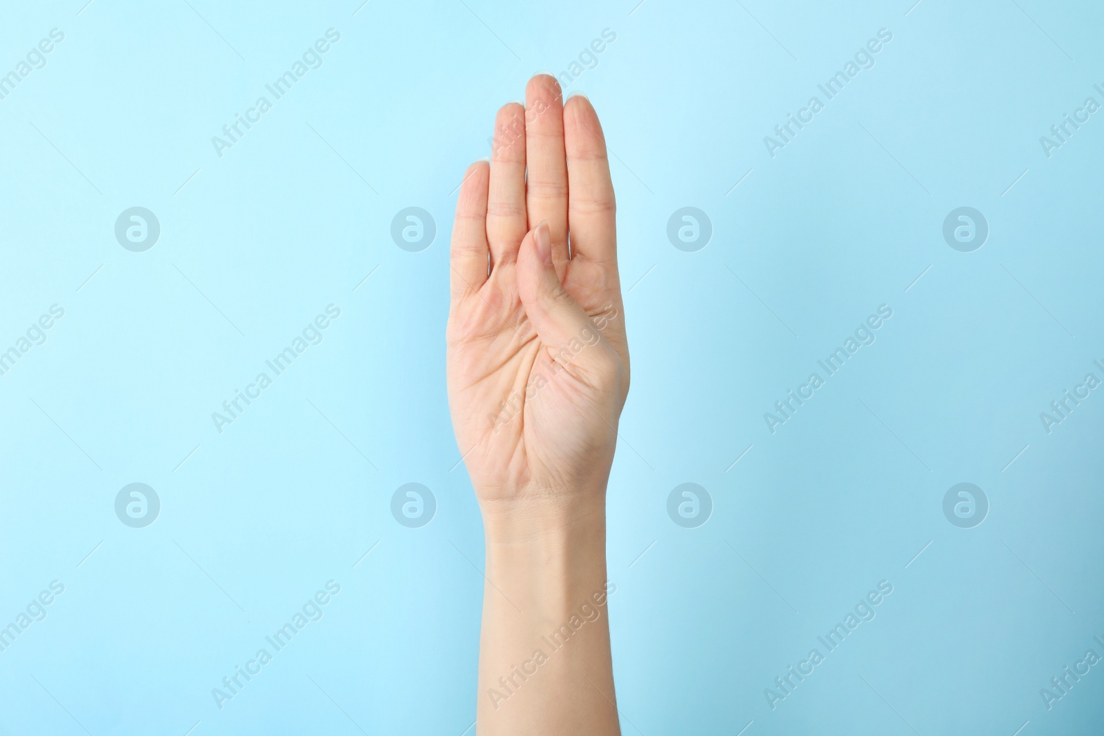 Photo of Woman showing B letter on color background, closeup. Sign language