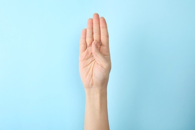 Photo of Woman showing B letter on color background, closeup. Sign language