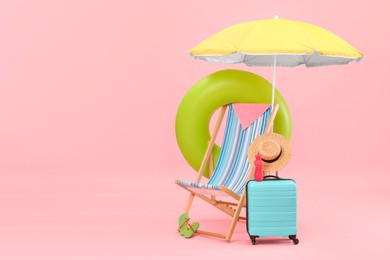 Photo of Deck chair, umbrella, suitcase and beach accessories against pink background, space for text. Summer vacation