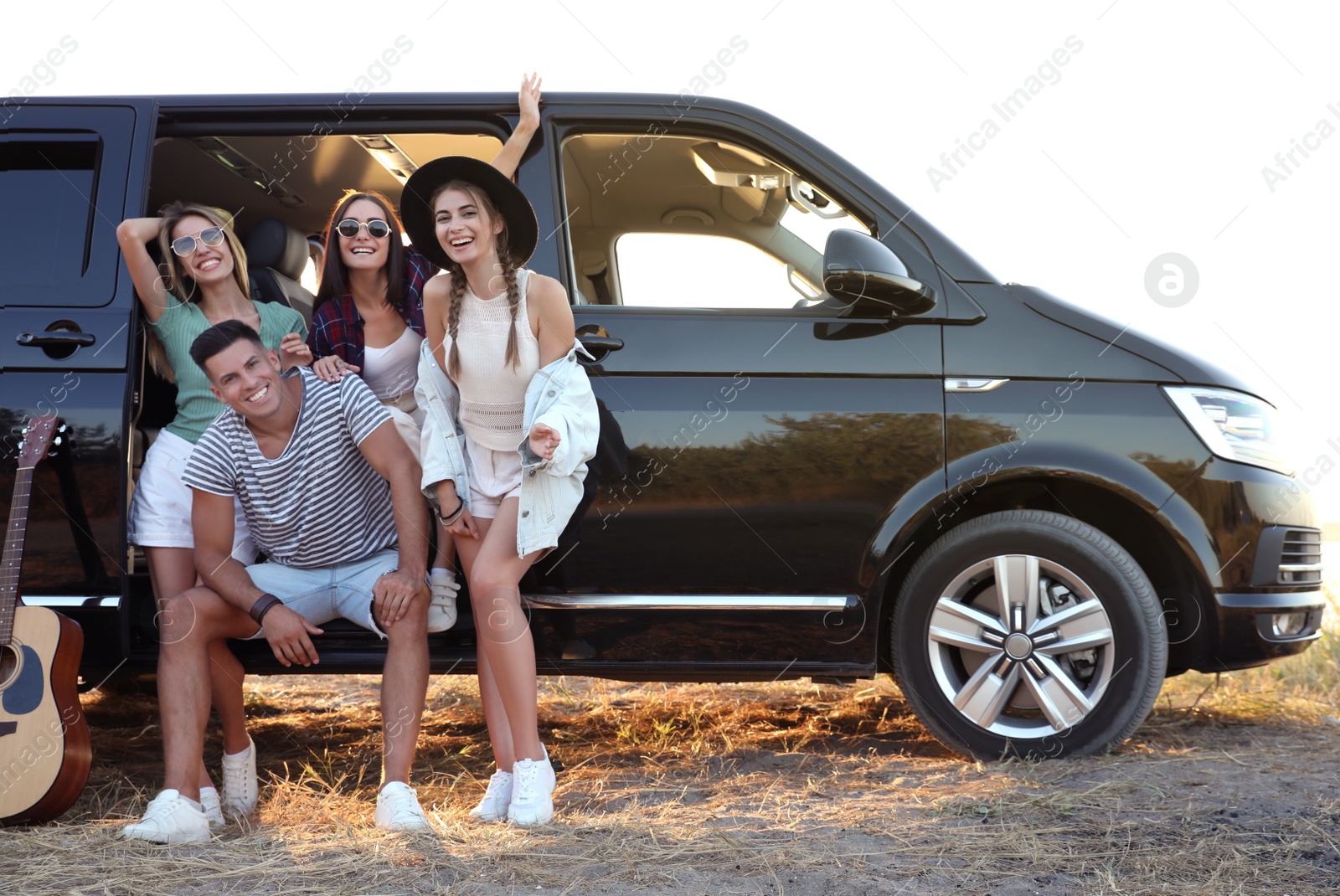 Photo of Happy friends near car outdoors. Summer trip