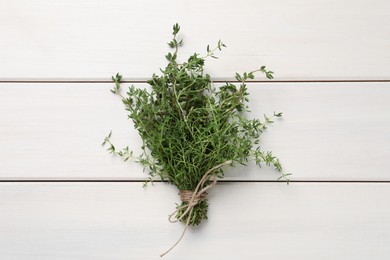 Bunch of aromatic thyme on white wooden table, top view