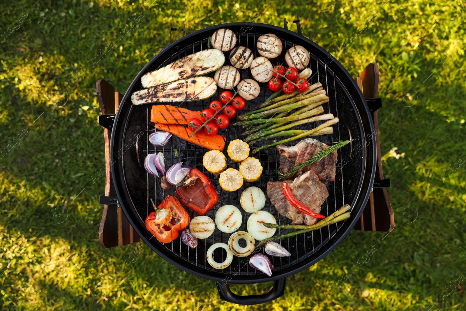 Photo of Delicious grilled vegetables and meat on barbecue grill outdoors, top view