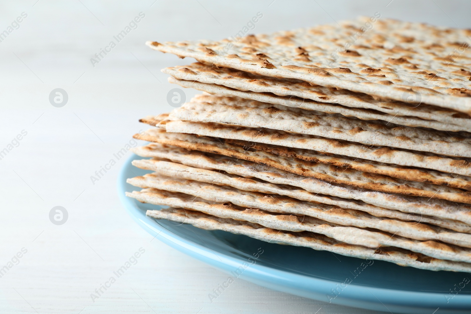 Photo of Stack of matzos on white table, closeup