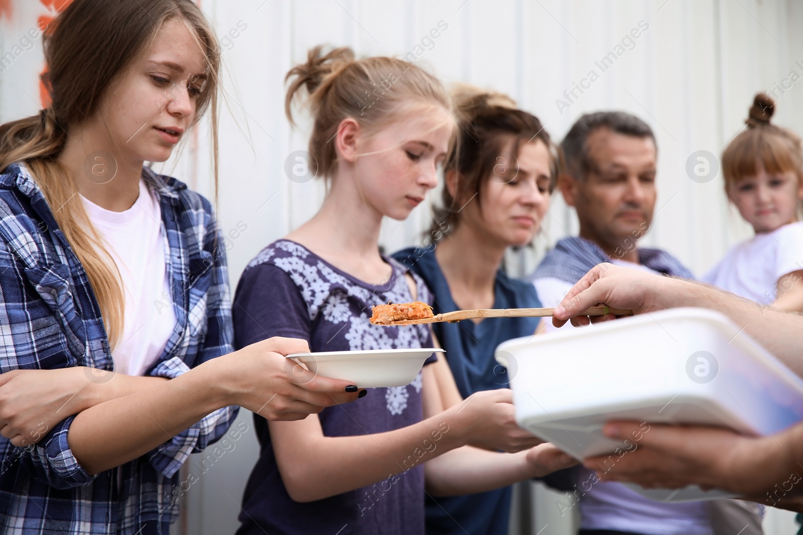 Photo of Poor people receiving food from volunteer outdoors