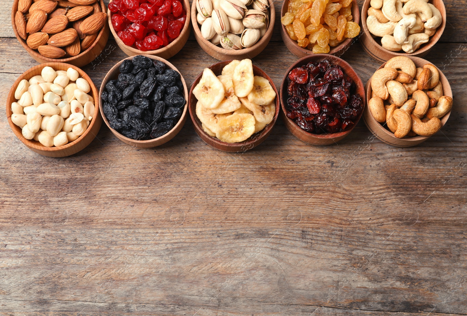 Photo of Composition of different dried fruits and nuts on wooden background, top view. Space for text