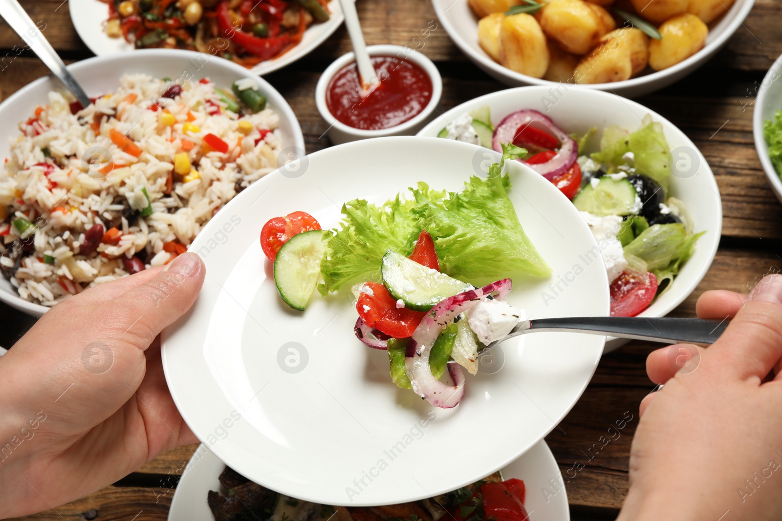 Photo of Woman taking food from buffet table, closeup