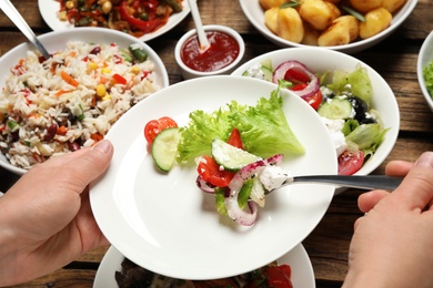 Woman taking food from buffet table, closeup