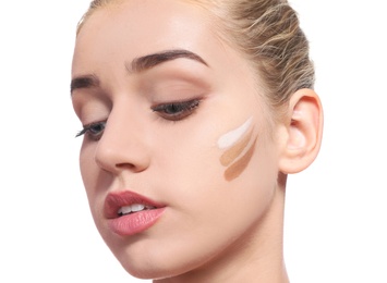 Young woman with different shades of skin foundation on her face against white background. Professional makeup