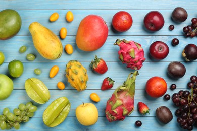 Many different delicious exotic fruits on blue wooden table, flat lay