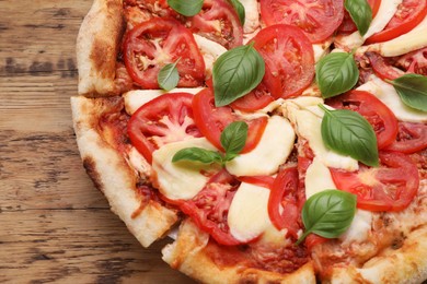 Photo of Delicious Caprese pizza on wooden table, top view