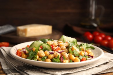 Photo of Plate with delicious fresh chickpea salad on table