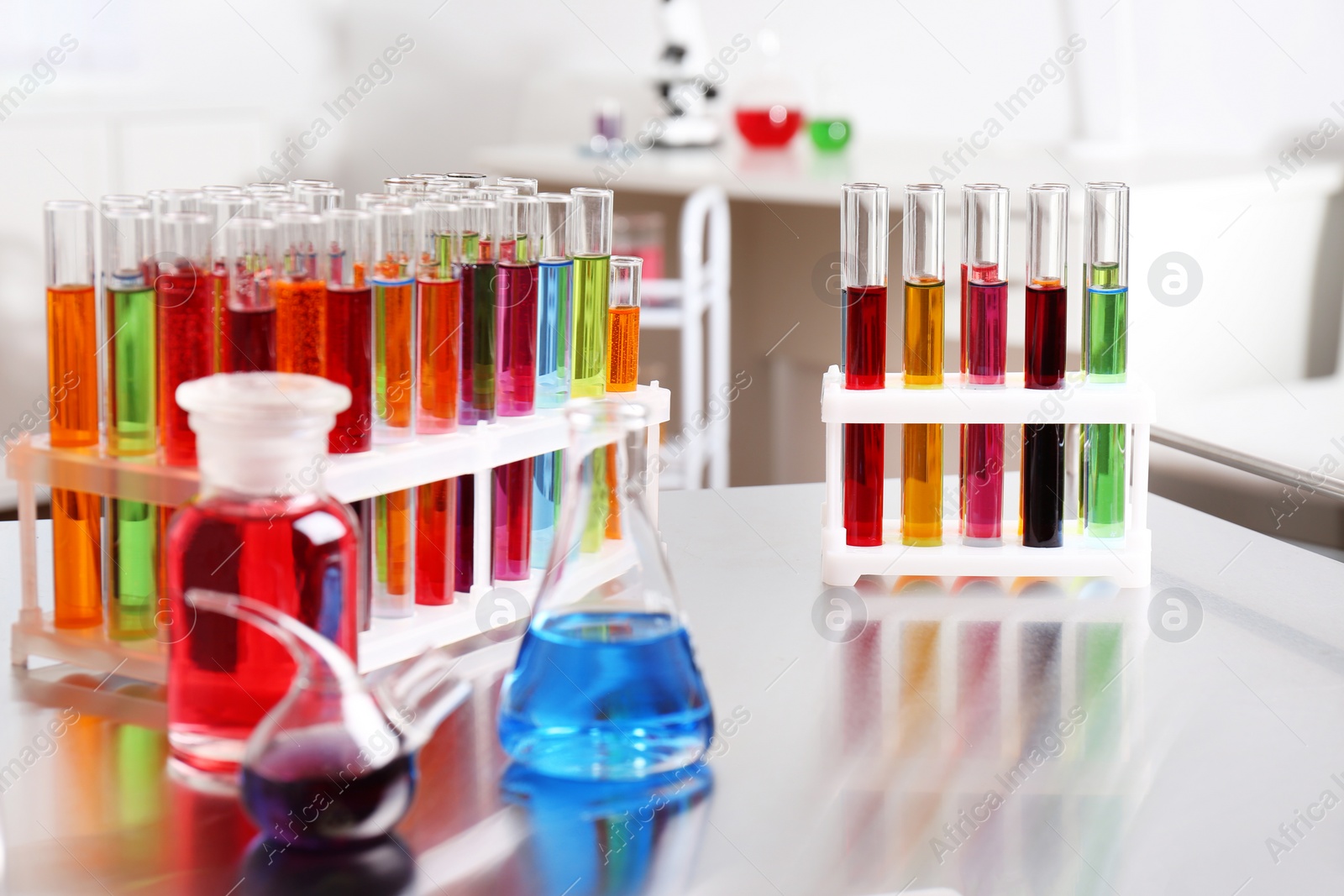 Photo of Laboratory glassware with color liquids on table. Solution chemistry