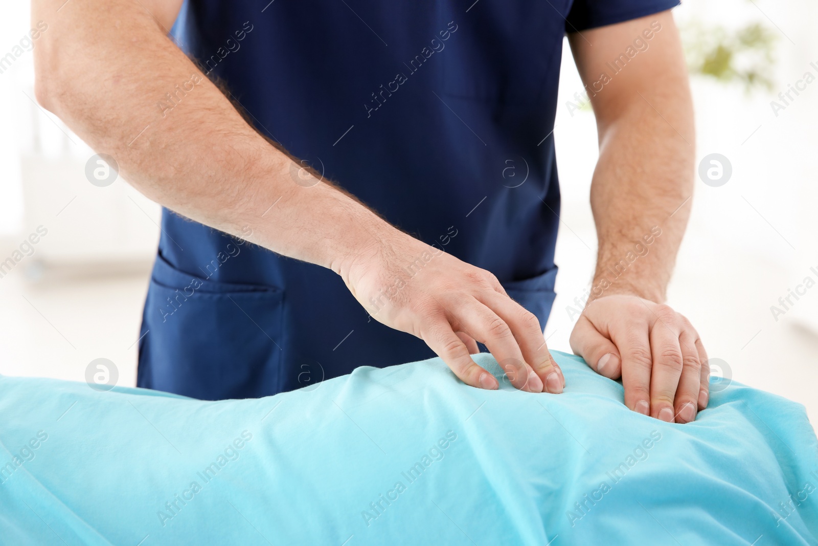 Photo of Young physiotherapist working with patient in clinic