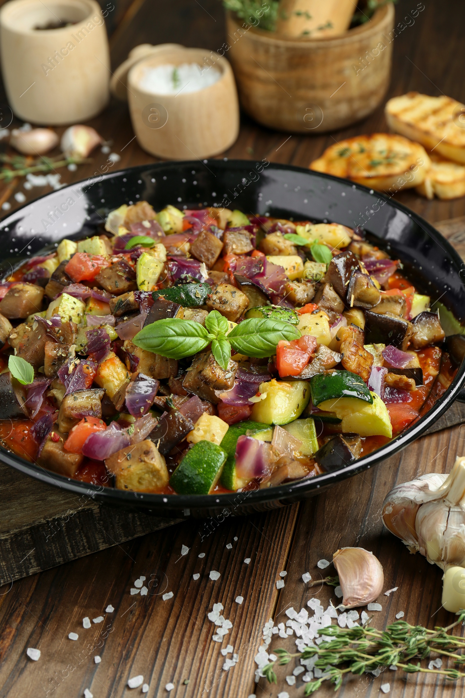 Photo of Delicious ratatouille in baking dish served on wooden table, closeup