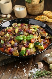 Photo of Delicious ratatouille in baking dish served on wooden table, closeup