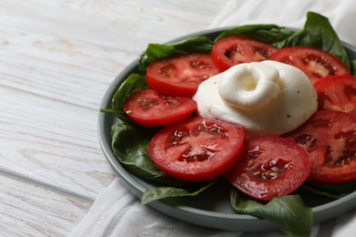 Delicious burrata cheese with tomatoes and basil on white wooden table, closeup. Space for text