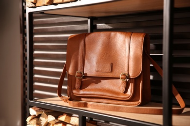 Photo of Stylish woman's bag on shelf in boutique