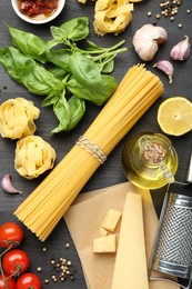 Photo of Different types of pasta, products, peppercorns and garter on dark wooden table, flat lay