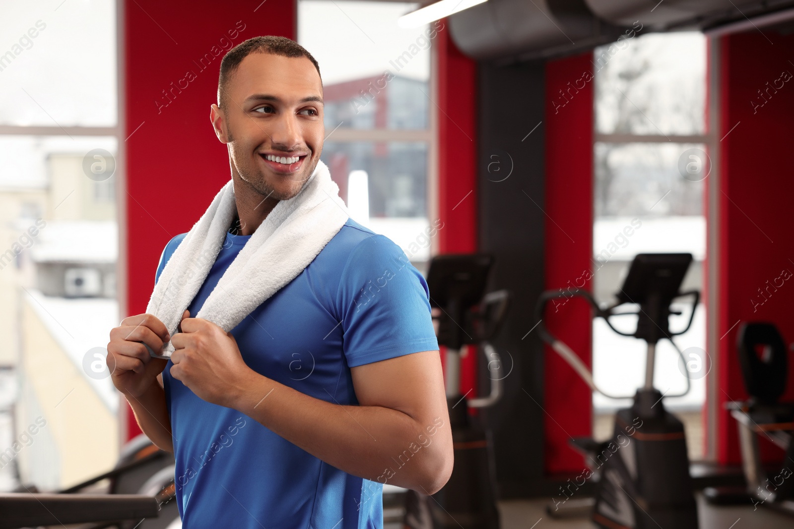 Photo of Happy trainer in modern gym, space for text