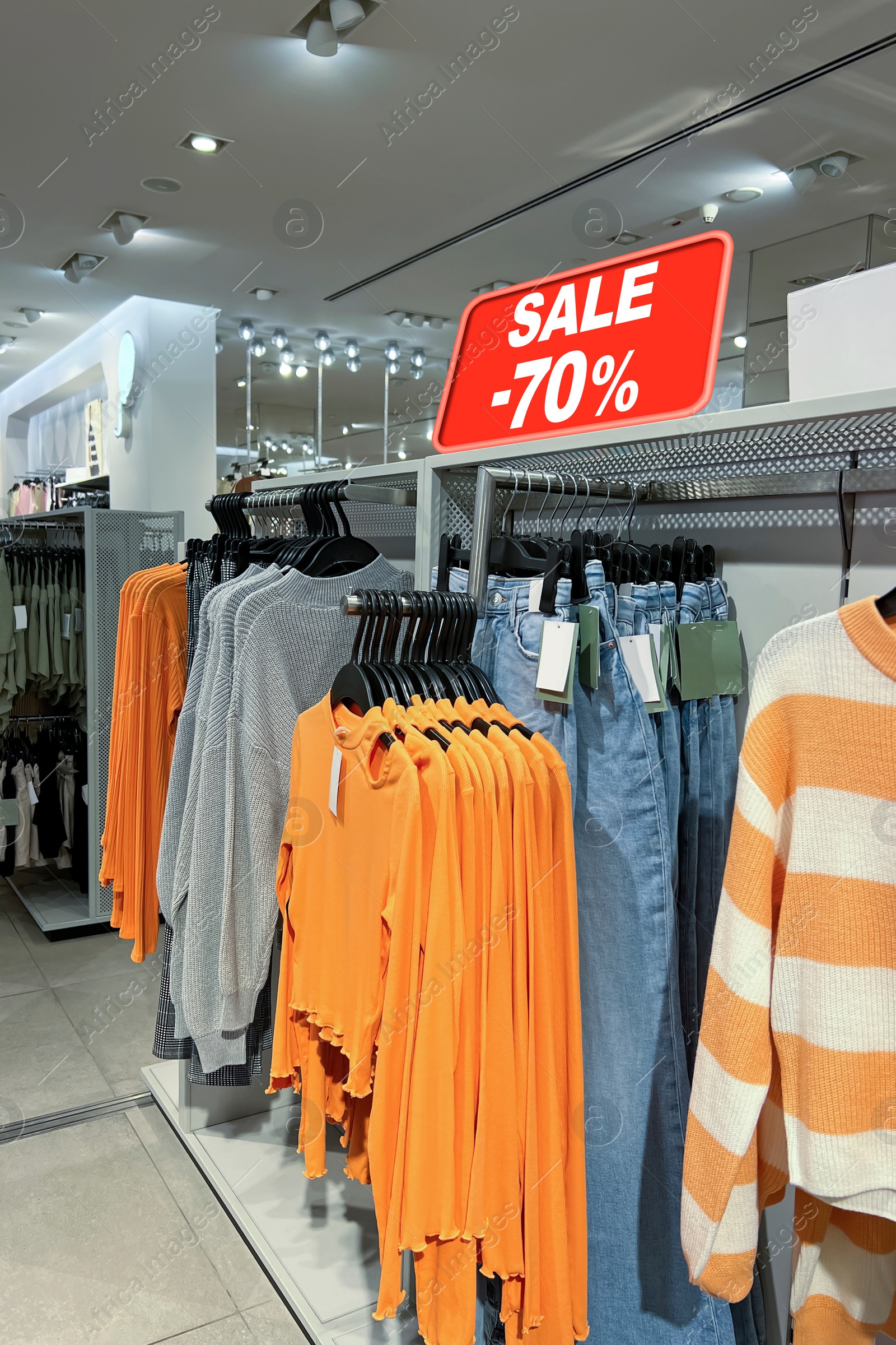 Image of Sale sign and collection of stylish women's clothes in fashion store