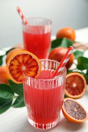 Photo of Tasty sicilian orange juice and fruits on white wooden table