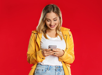 Photo of Beautiful woman using phone on red background