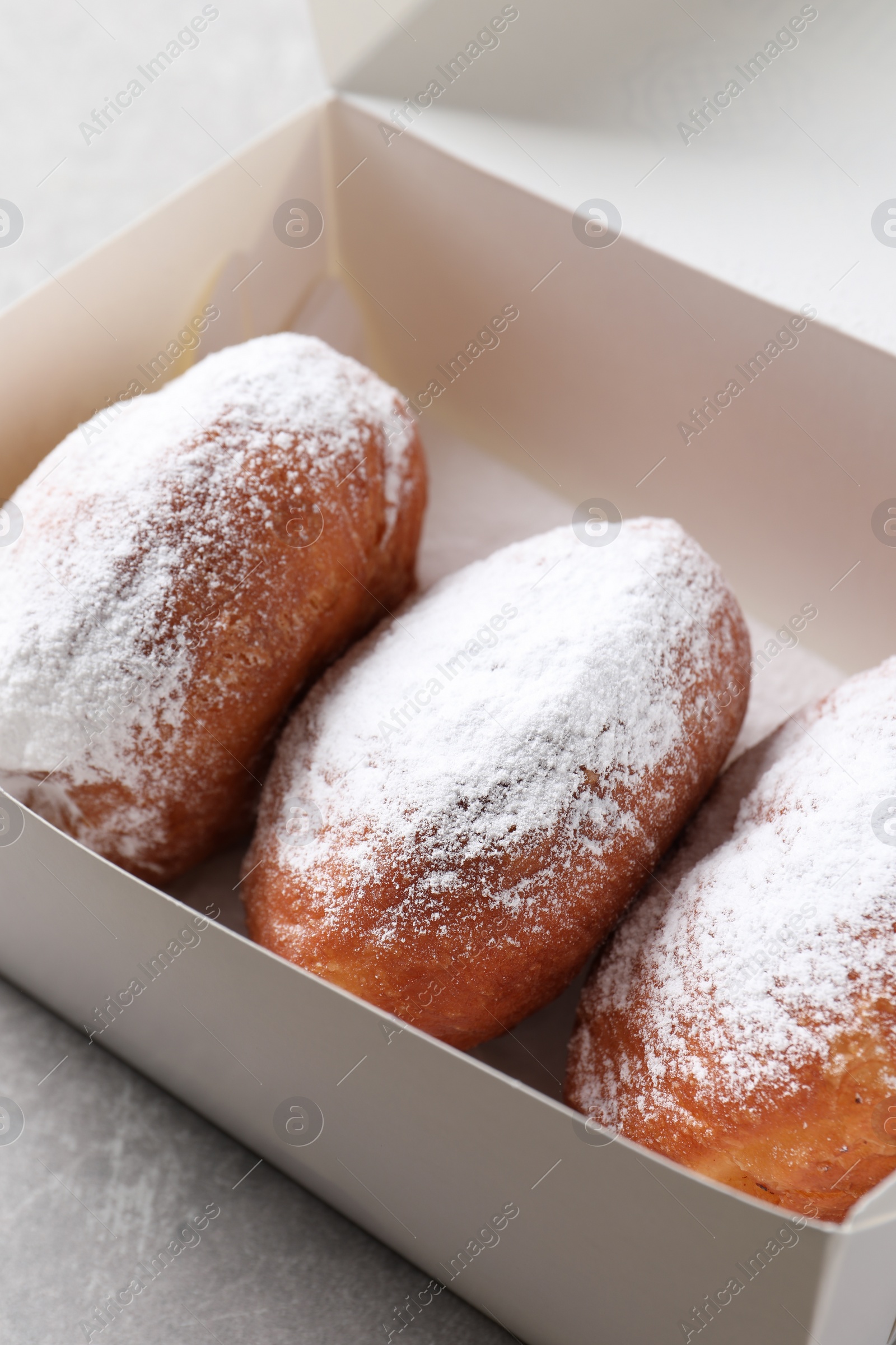 Photo of Delicious sweet buns in box on table, closeup