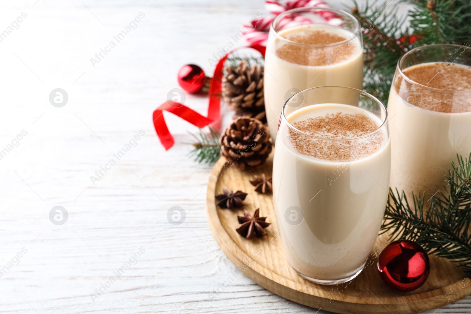 Photo of Delicious Christmas cocktail with liqueur on white wooden table. Space for text